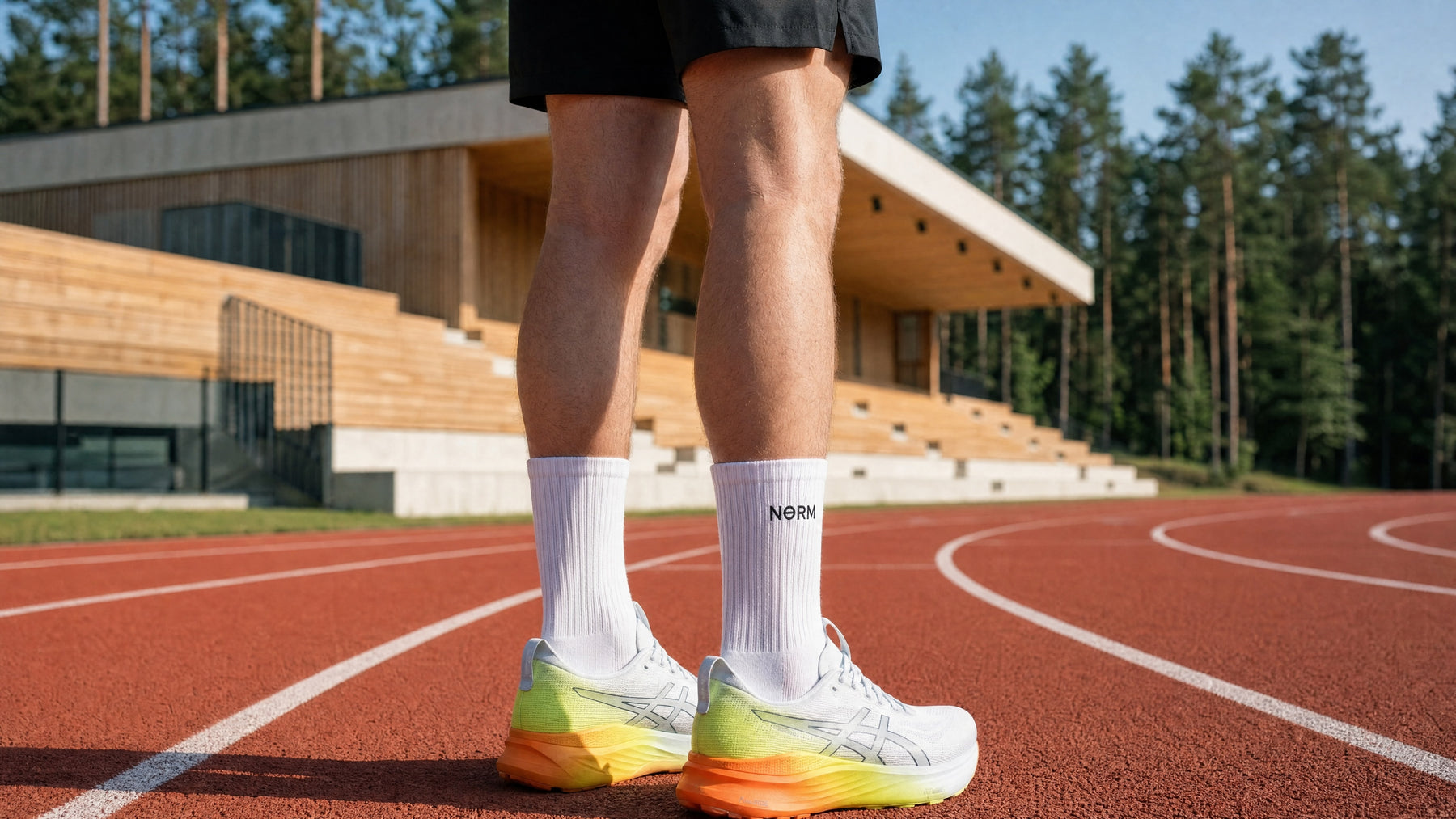 NƟRM white crew socks worn on an athletics track