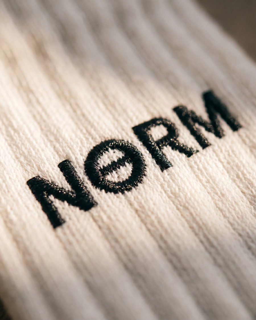 Folded NƟRM crew sock on linen