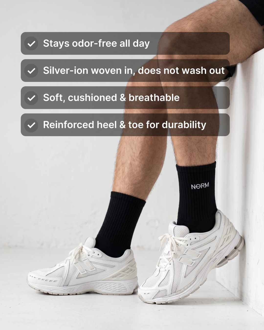 NƟRM Signature Crew in black worn with white sneakers. Stays odor-free all day, silver-ion woven in, soft cushioned and breathable, reinforced heel and toe.
