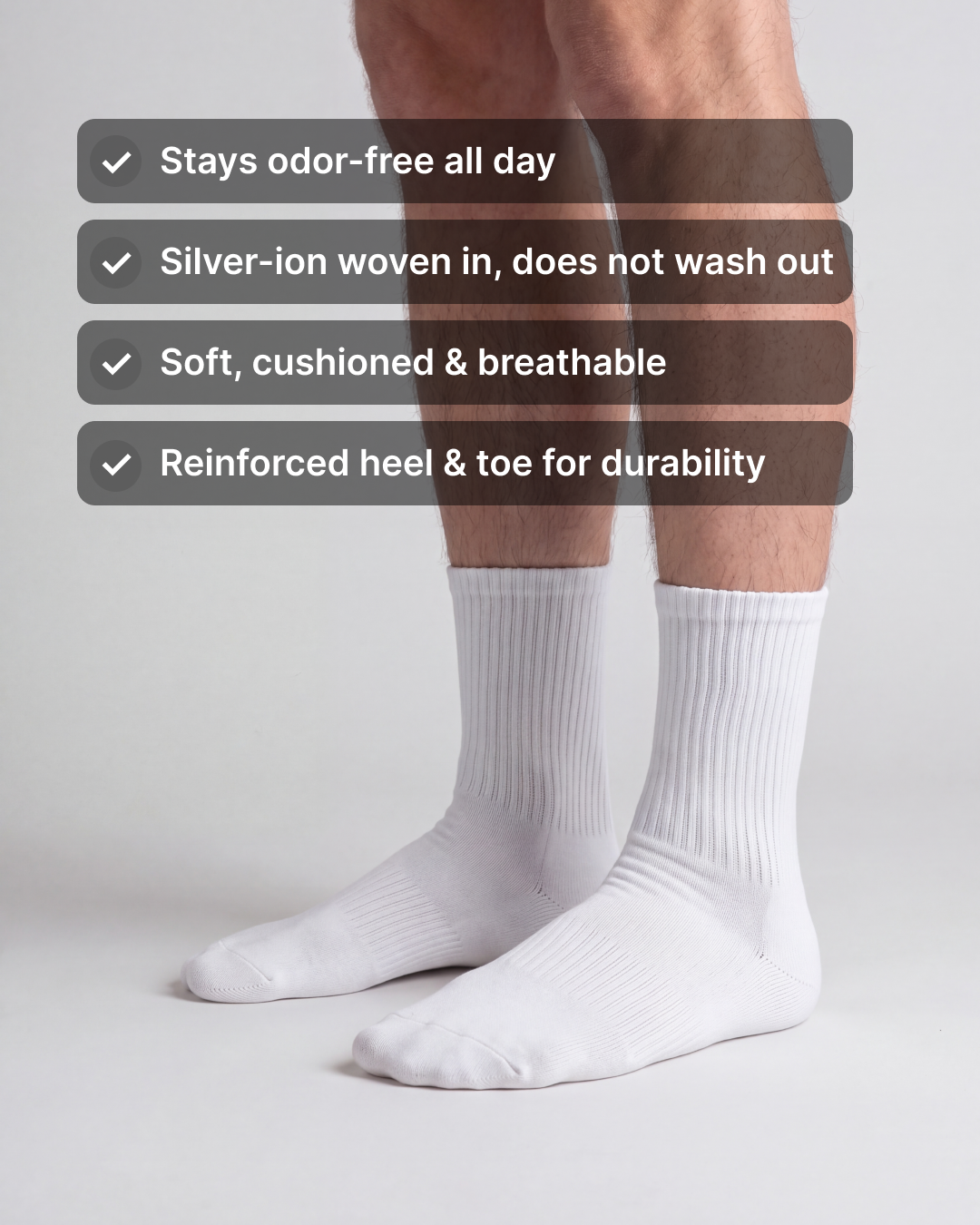 NƟRM Plain Crew in white worn standing. Stays odor-free all day, silver-ion woven in, soft cushioned and breathable, reinforced heel and toe.